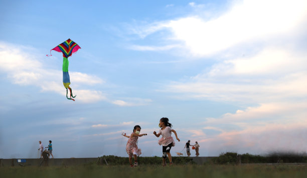 亚洲女孩在草地上玩和放风筝。图片下载