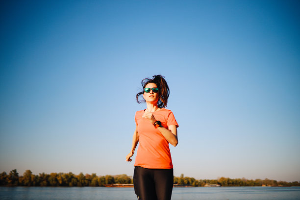 一位年轻女子在河边做慢跑锻炼图片下载