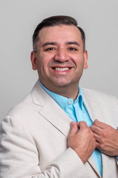 微笑的成熟男子看着灰色背景的相机图片下载