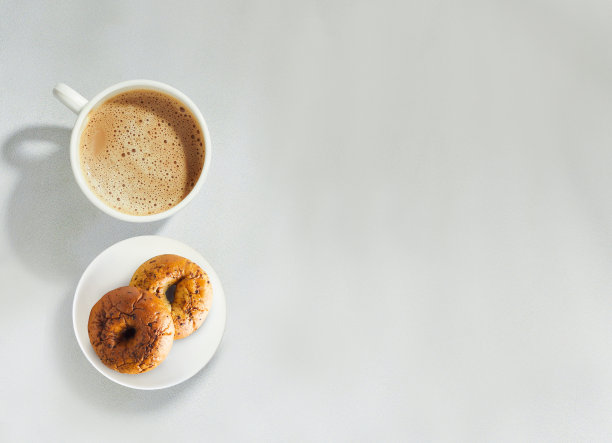 瓷杯茶和甜甜圈的顶部角度在盘子上孤立的白色背景与复制空间图片下载