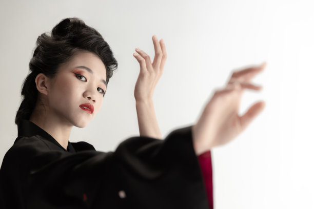 年轻美丽的日本人的肖像，妇女在民族服装和服摆出孤立的白色工作室背景。图片下载