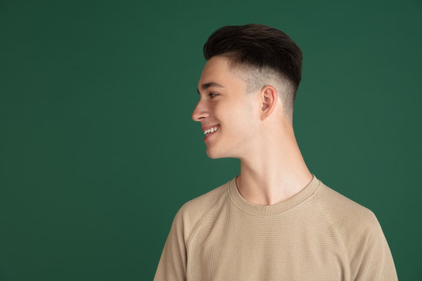 年轻的白人男孩的肖像孤立在绿色工作室的背景。面部表情，人类情感的概念。图片下载