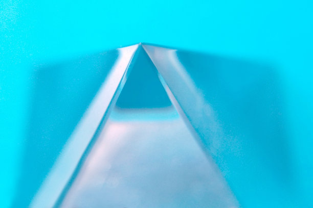 玻璃金字塔在一个蓝色的背景上的特写模糊的背景顶部图片下载