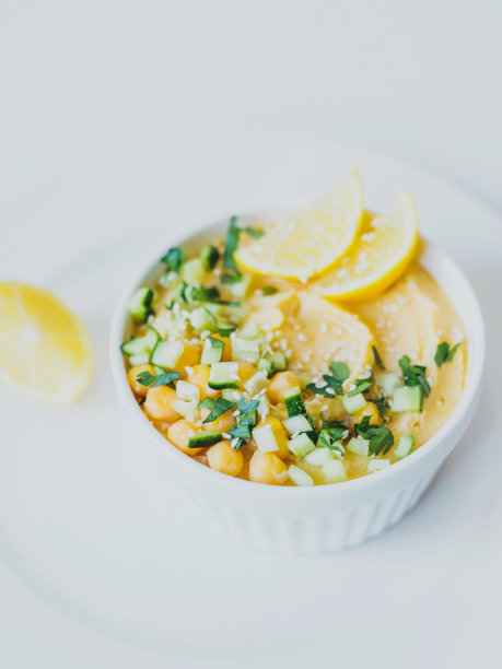 鹰嘴豆泥，橄榄油，柠檬，芝麻和黄瓜，白色背景。图片下载