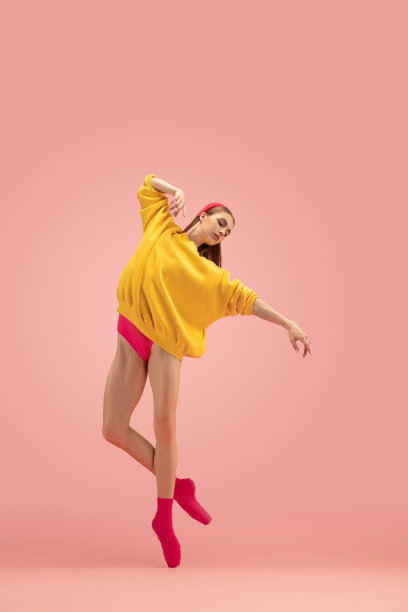 苗条柔嫩的年轻美丽的女孩，女芭蕾舞者舞蹈孤立在粉红色的背景。图片下载