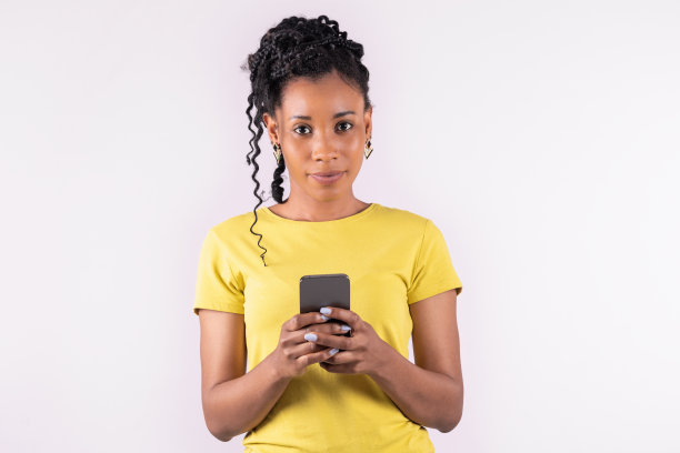 美国黑人妇女拿着她的手机冷静地看着相机:表情概念。图片下载