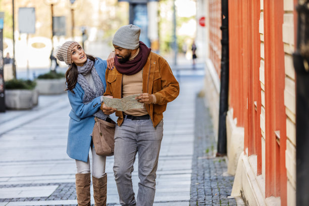 一对年轻的游客正在用地图愉快地探索这个城市。图片下载