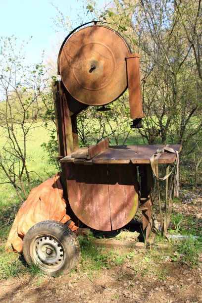 生锈的带轮子的旧带锯图片下载