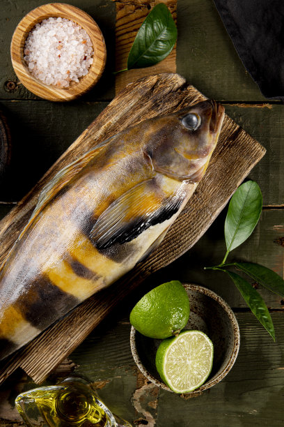 生鱼海鲈鱼或鳕鱼和调味料烹饪它在木制背景俯视图，垂直照片图片下载