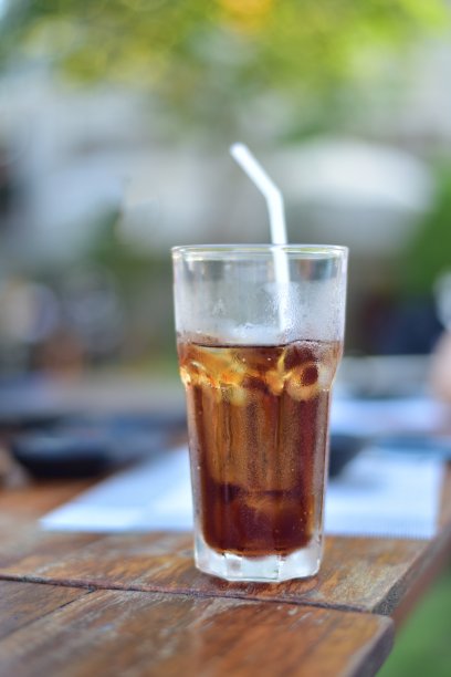 在木桌上的玻璃杯里加冰的水。图片下载