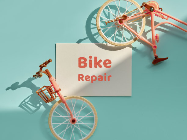 自行车修理车间。自行车修理平铺着破损的玩具模型的城镇自行车。俯视图薄荷绿色和粉红色的纸背景与复古的文本图片下载