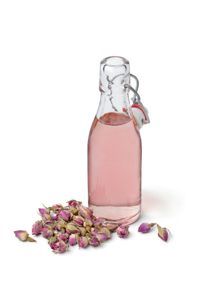 玫瑰花蕾水在一个玻璃瓶在白色的背景图片下载