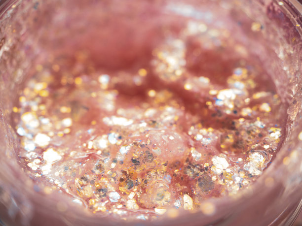 粉色的亮片质地，小的多色装饰亮片可以用于节日妆容或指甲。美丽的概念。图片下载