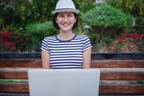 夏天城市公园里用笔记本电脑找工作的女人图片下载