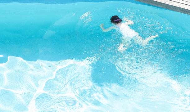 孩子在室外游泳池里洗澡。湛蓝清澈的池水。图片下载