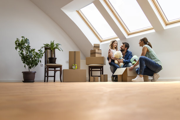 幸福的家庭和孩子们搬进新家，一起拆箱子。图片下载