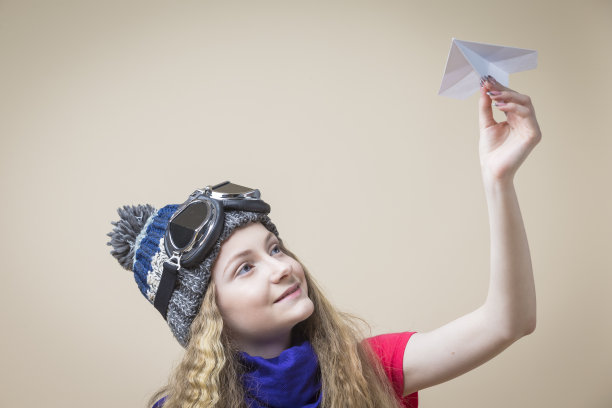 少女戴眼镜帽与折纸飞机图片下载