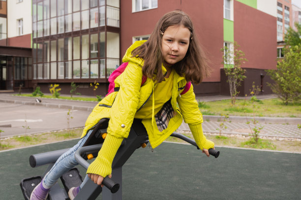 一名9岁的女学生正在院子里的模拟器上健身图片下载