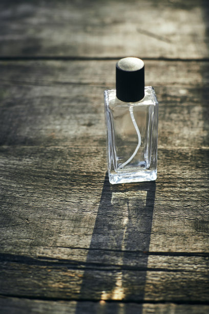 在夕阳下，在森林里的一棵树上，放着一瓶香水。广告照片。模型图片下载