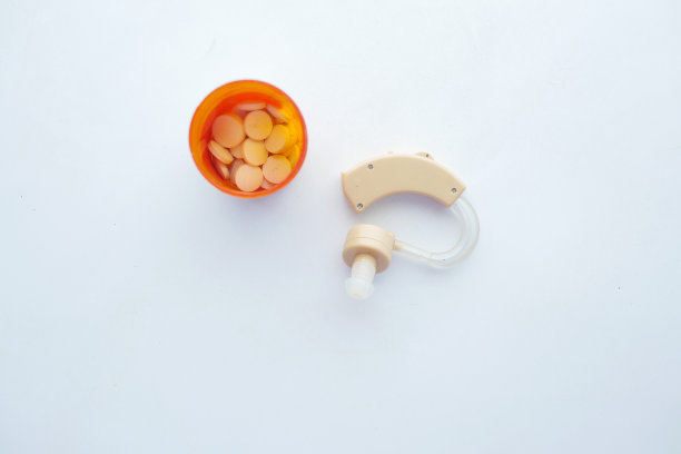 助听器设备和医药药丸容器的白色背景图片下载