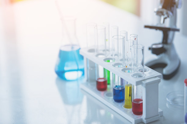 实验室桌上放置显微镜和彩色试管。科学化学概念。蓝色的基调图片下载