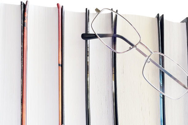 白色背景上的眼镜和厚厚的书。教育理念图片下载