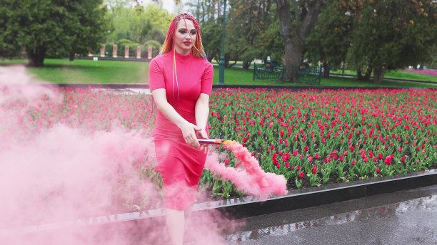 一个女孩带着彩虹辫，穿着红裙子摆姿势图片下载