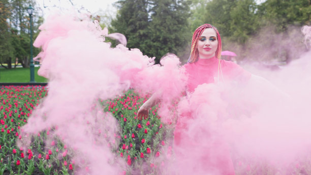 一个女孩带着彩虹辫，穿着红裙子摆姿势图片下载