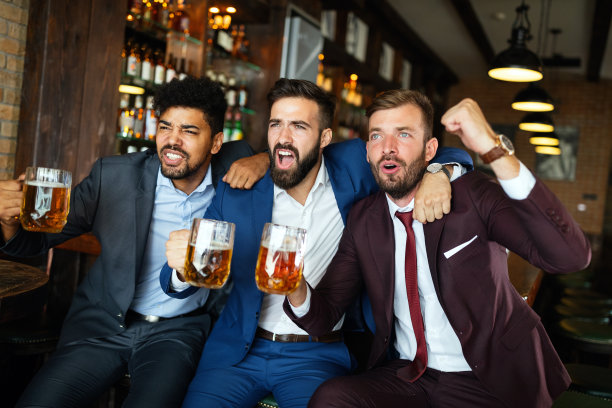 一群朋友在酒吧看足球比赛，喝啤酒图片下载