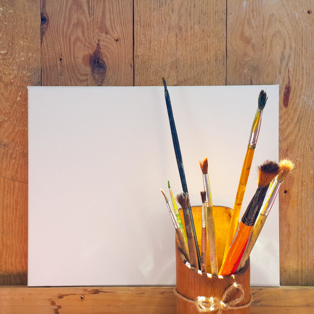 桶里的旧刷子。在木制背景上作画的空白画布。艺术家的工作场所。广场-作文图片下载