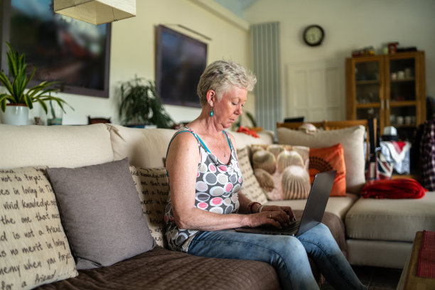 一个用笔记本电脑工作的退休妇女图片下载