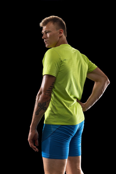 白人职业男运动员，跑步者孤立地站在黑人演播室背景上。肌肉,运动的人。图片下载