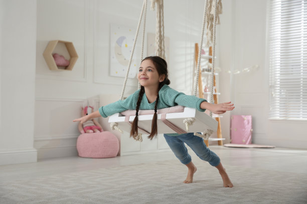 可爱的小女孩在家里玩秋千图片下载