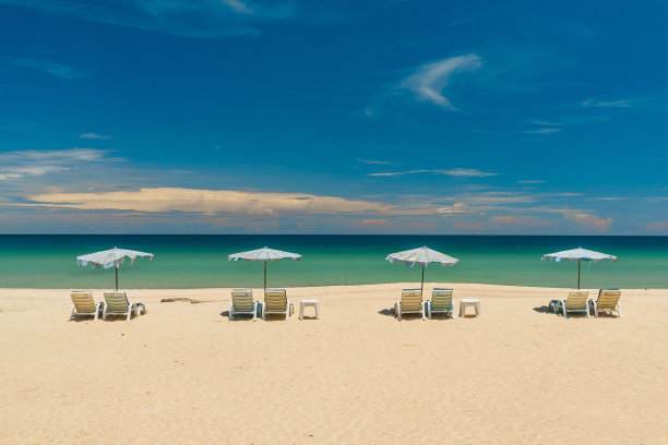 沙滩椅，雨伞和一个美丽的海滩在一个阳光明媚的日子。暑期旅游与自然探险理念。图片下载