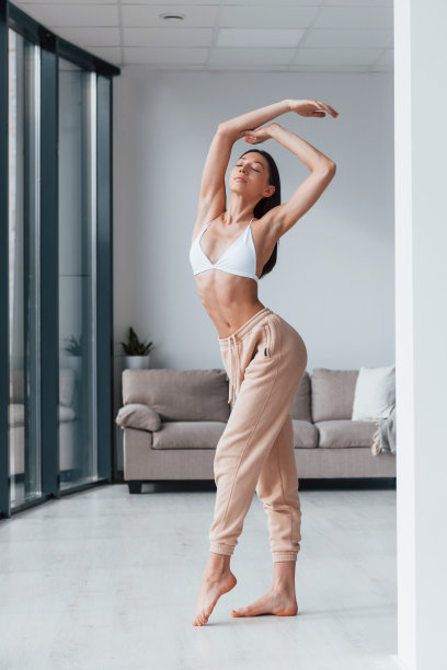 白天，穿着白色内衣的苗条女人站在室内图片下载