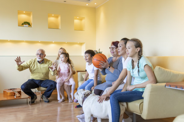 一个幸福的家庭在家里看篮球比赛。图片下载