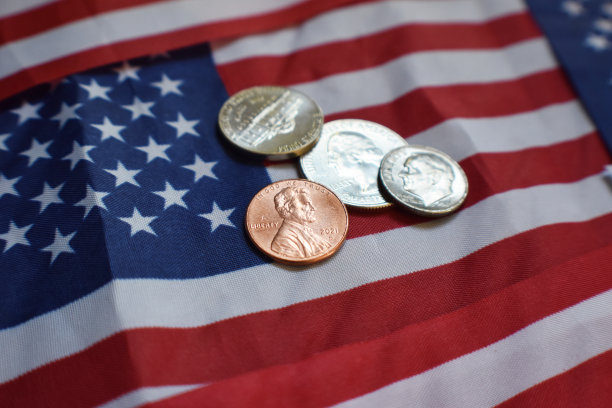 股息收入概念从拥有美国公司的经纪帐户支付美国国旗上的便士，一角，镍币和季度股息图片下载