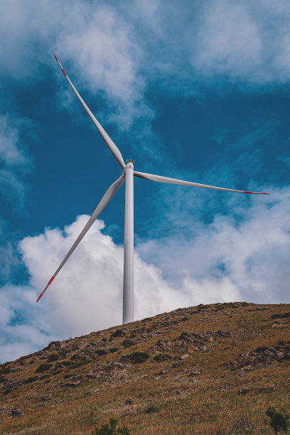 阴天下的草原上的风力发电机图片下载
