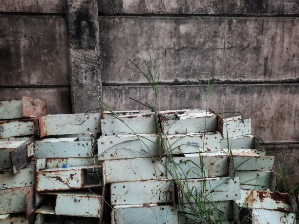 混凝土墙旁的废弃铁厂。图片下载
