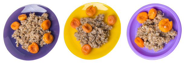 健康食品。rzhanye薄片和杏干放在盘子里。雨点落在白色的背景上。顶视图的早餐图片下载