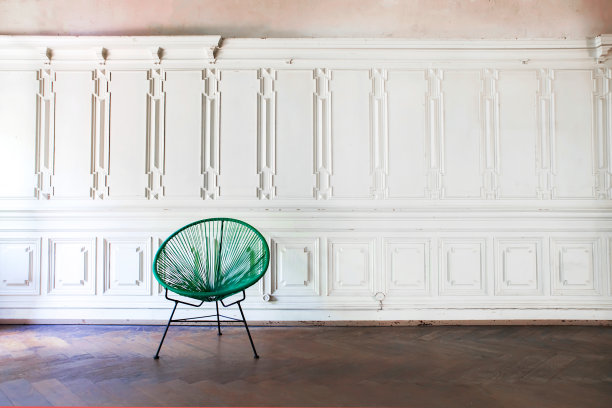绿色复古钢丝网椅子在空房间与灰泥元素墙背景。客厅与古董时尚的绿色椅子在白色的墙壁设计图片下载