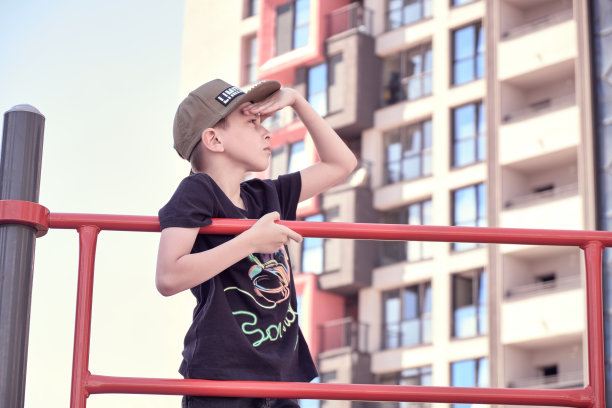 戴着帽子的男孩望着前方。夏天不带面罩的户外游戏。图片下载