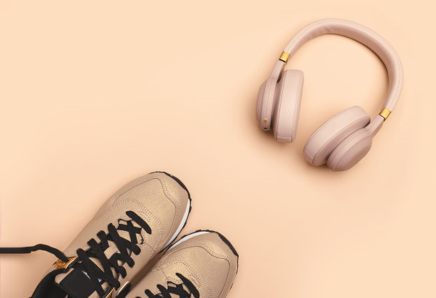 时髦的女孩夏天粉色的东西来散步:浅粉色背景的运动鞋和无线耳机，俯视图图片下载