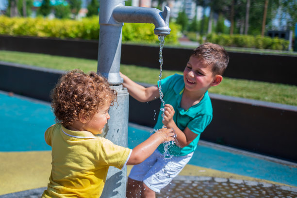 小男孩在水上公园的喷泉里玩耍。库存图片图片下载