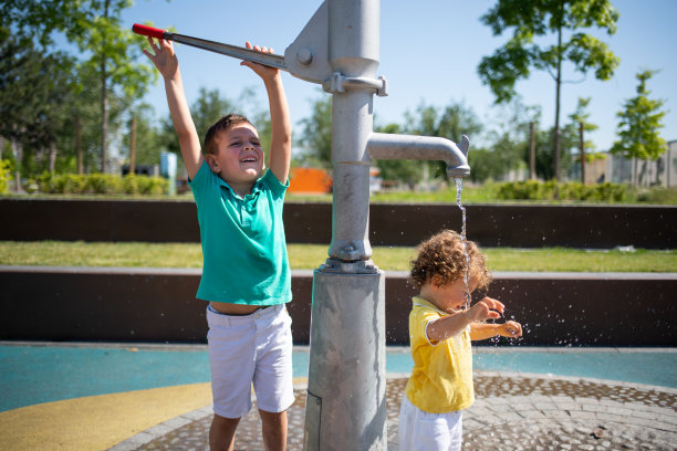 小男孩在水上公园的喷泉里玩耍。库存图片图片下载