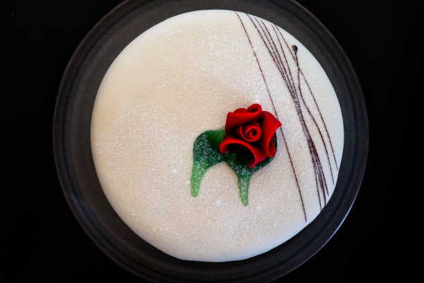 黑色背景下盘子上的白色蛋糕图片下载