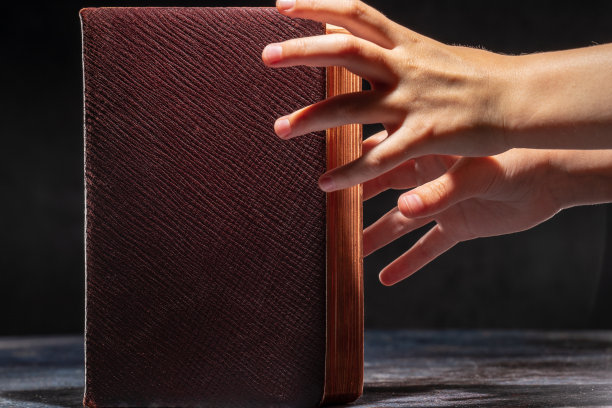 孩子的手伸向那本旧书。求知欲的概念图片下载