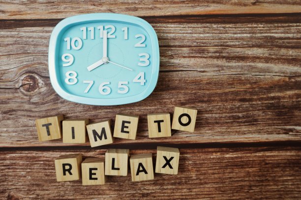 时间放松字母与闹钟在木制背景图片下载