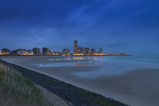 荷兰Vlissingen日落后退潮时的沙滩。背景是建筑物。在蓝色小时与长时间的照片图片下载