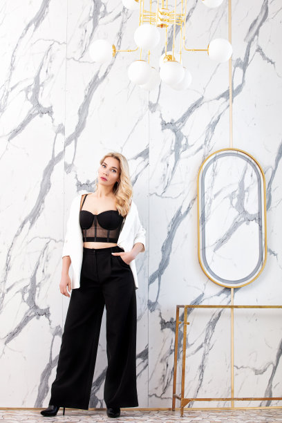 美丽的女模特，蓝眼睛的金发，穿着黑白相间的套装，夹克在内部有大理石图片下载